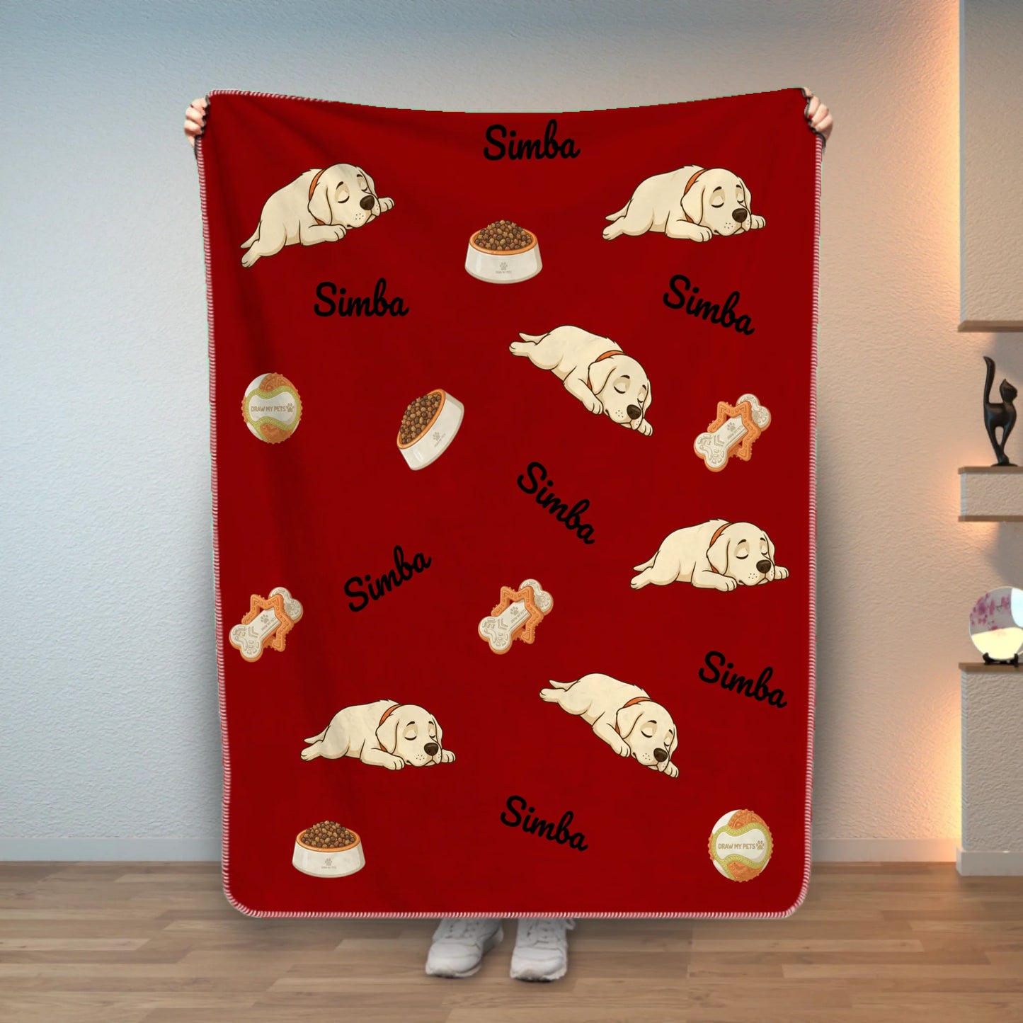 Couverture personnalisée rouge avec chiot Labrador endormi et prénom, tenue par une personne.