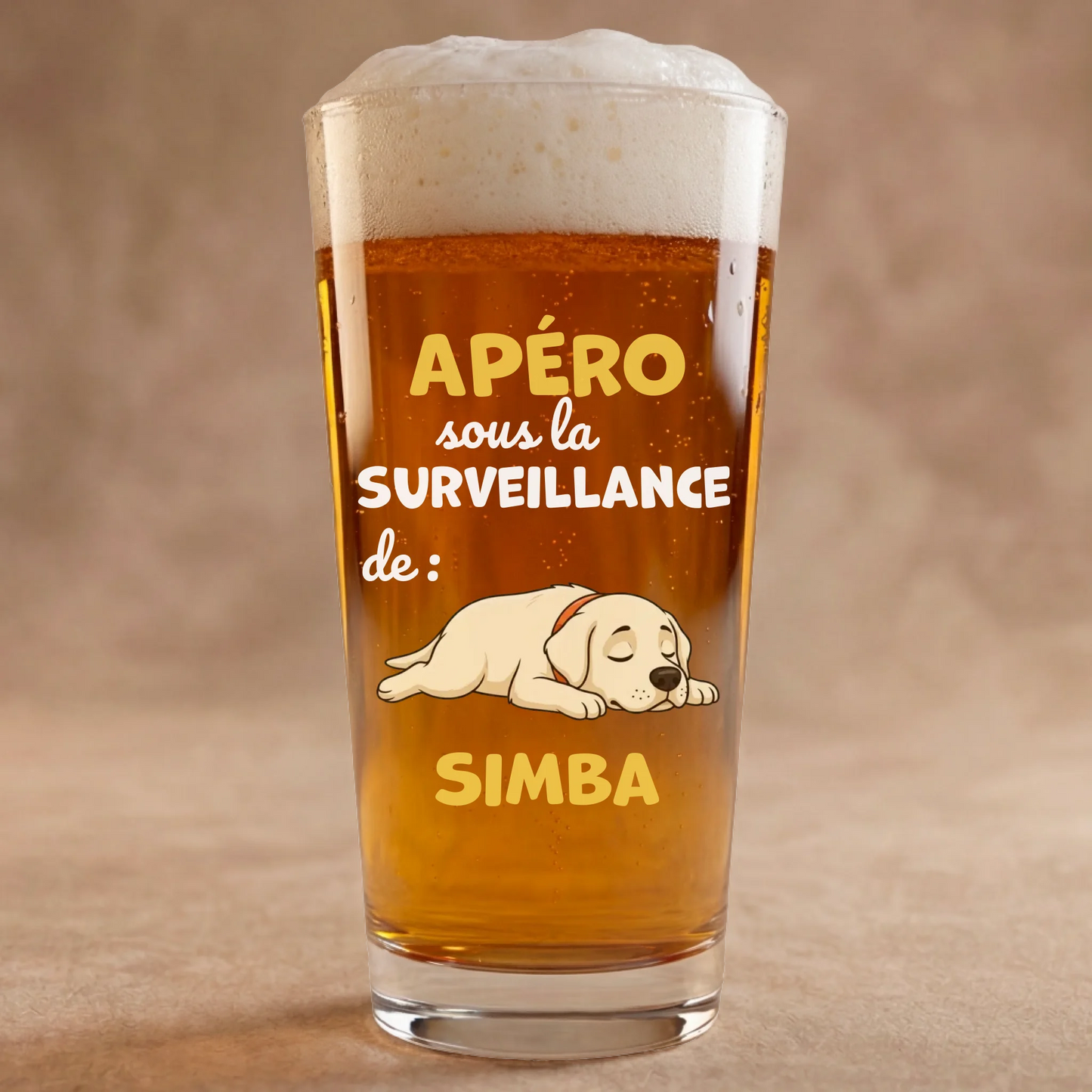 Verre à bière personnalisé avec illustration de chien endormi et texte 'Apéro sous la surveillance de Simba', mousse de bière dorée.