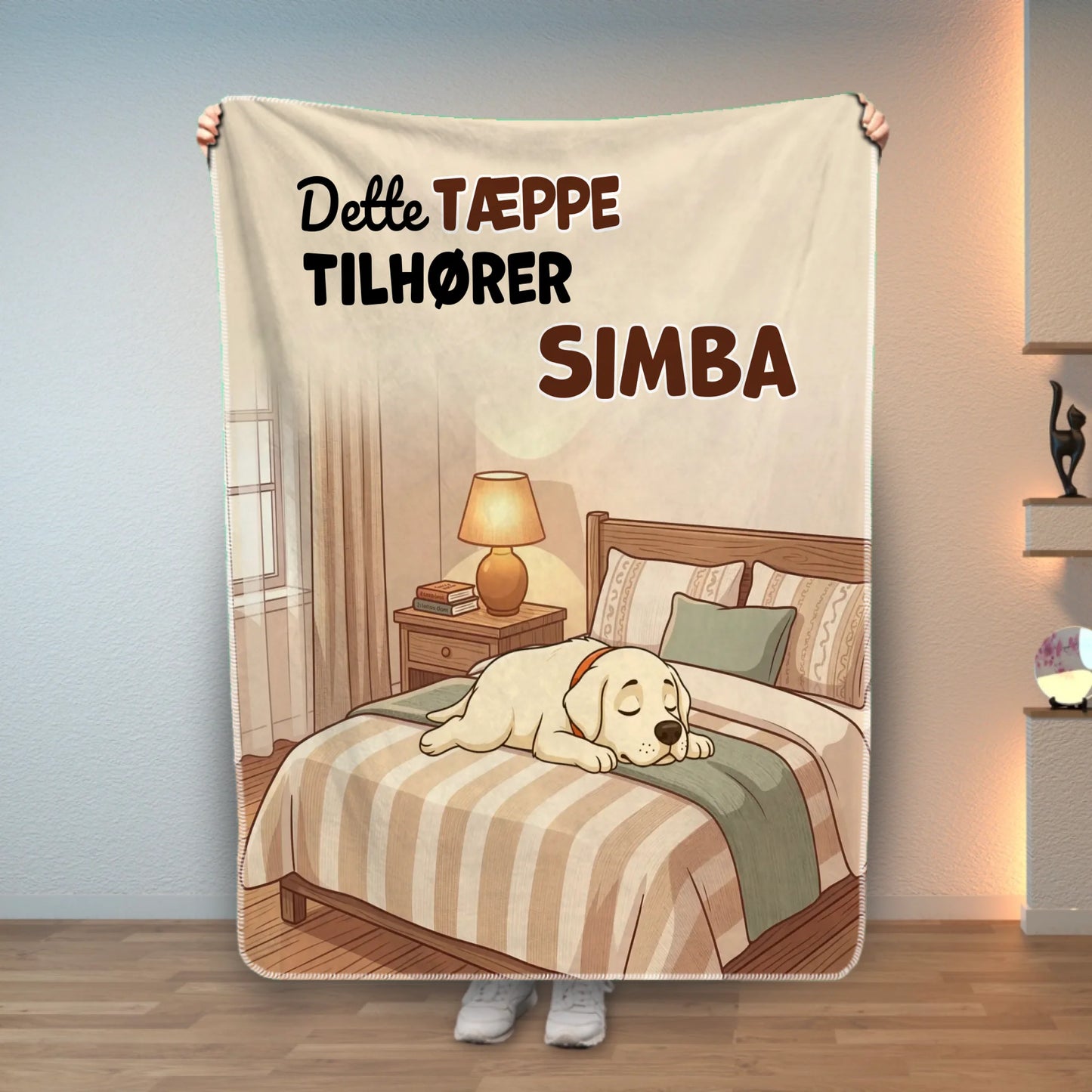 Personligt dyretæppe i mikrofiber med sovende gul labrador og teksten 'DETTE TÆPPE TILHØRER SIMBA' på en hyggelig seng.