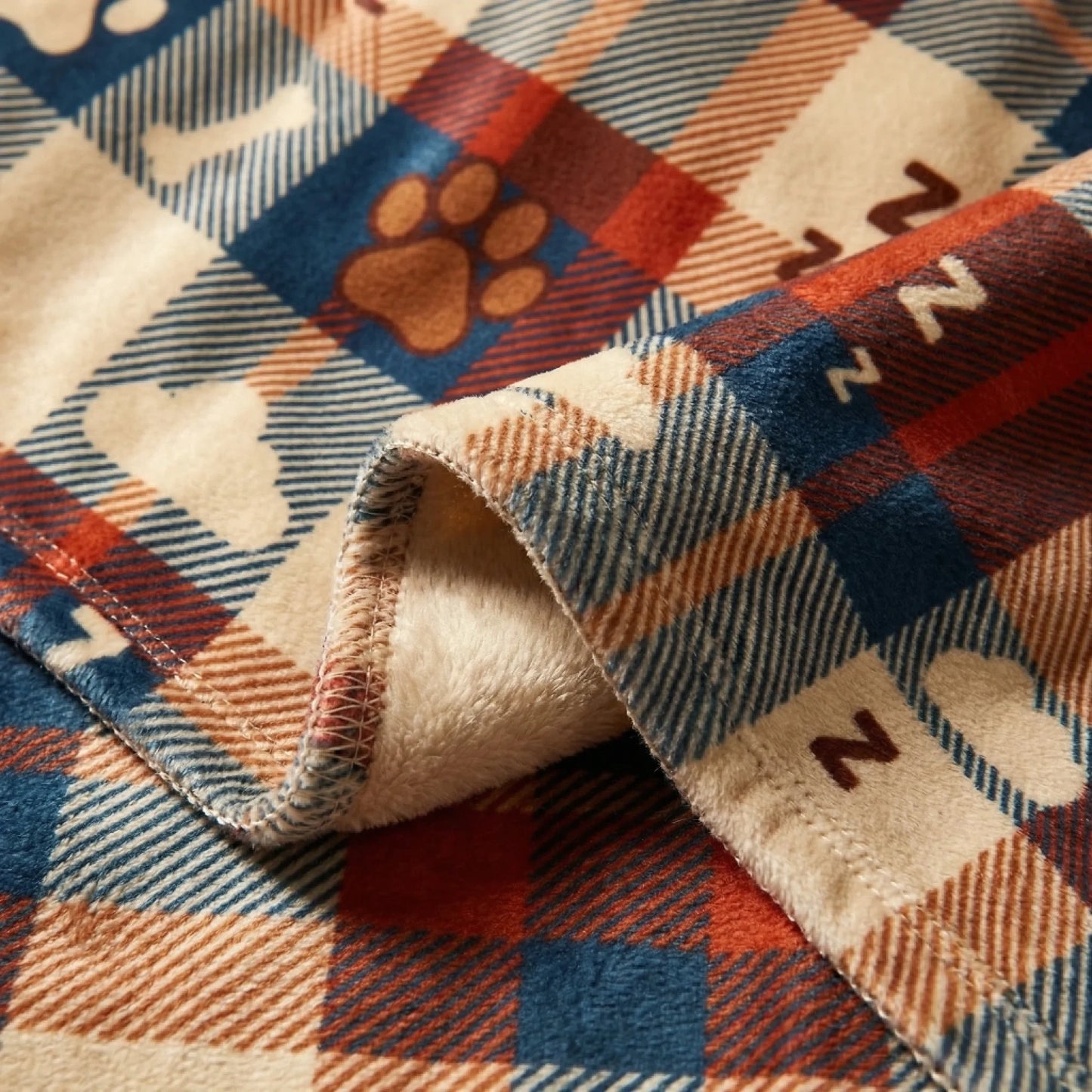 Détail du plaid 'NE PAS DÉRANGER' avec motif tartan, empreintes de pattes et symboles ZzZ