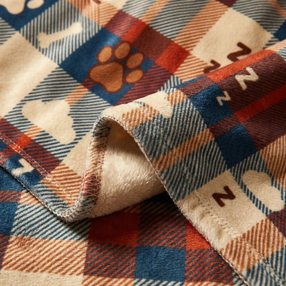 Détail du plaid 'NE PAS DÉRANGER' avec motif tartan, empreintes de pattes et symboles ZzZ