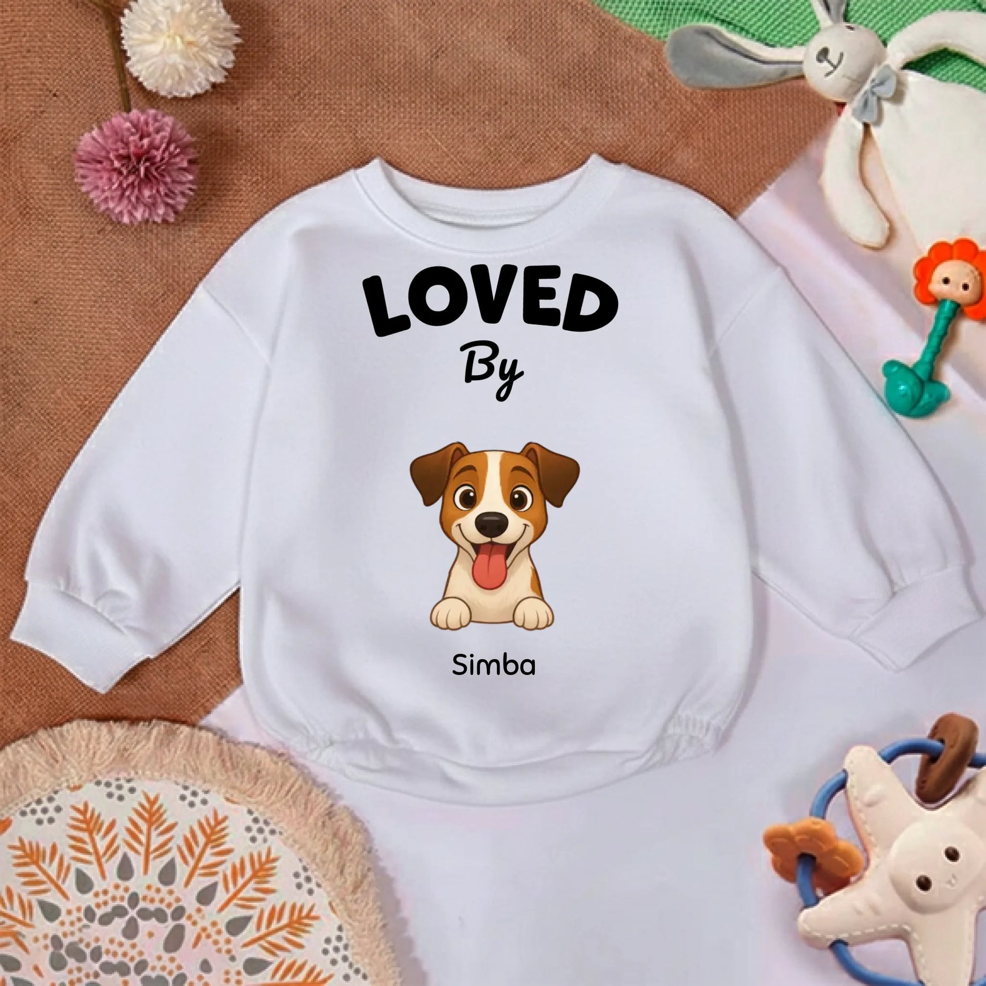 Détail du col et du texte "LOVED By" sur le pull bébé camel doux et confortable.