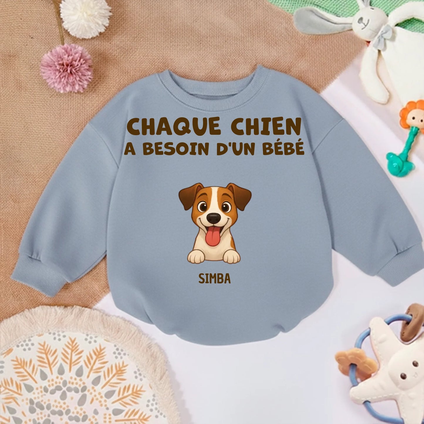 Pull bébé couleur terre de sienne posé à côté de jouets pour enfant, ambiance chaleureuse.