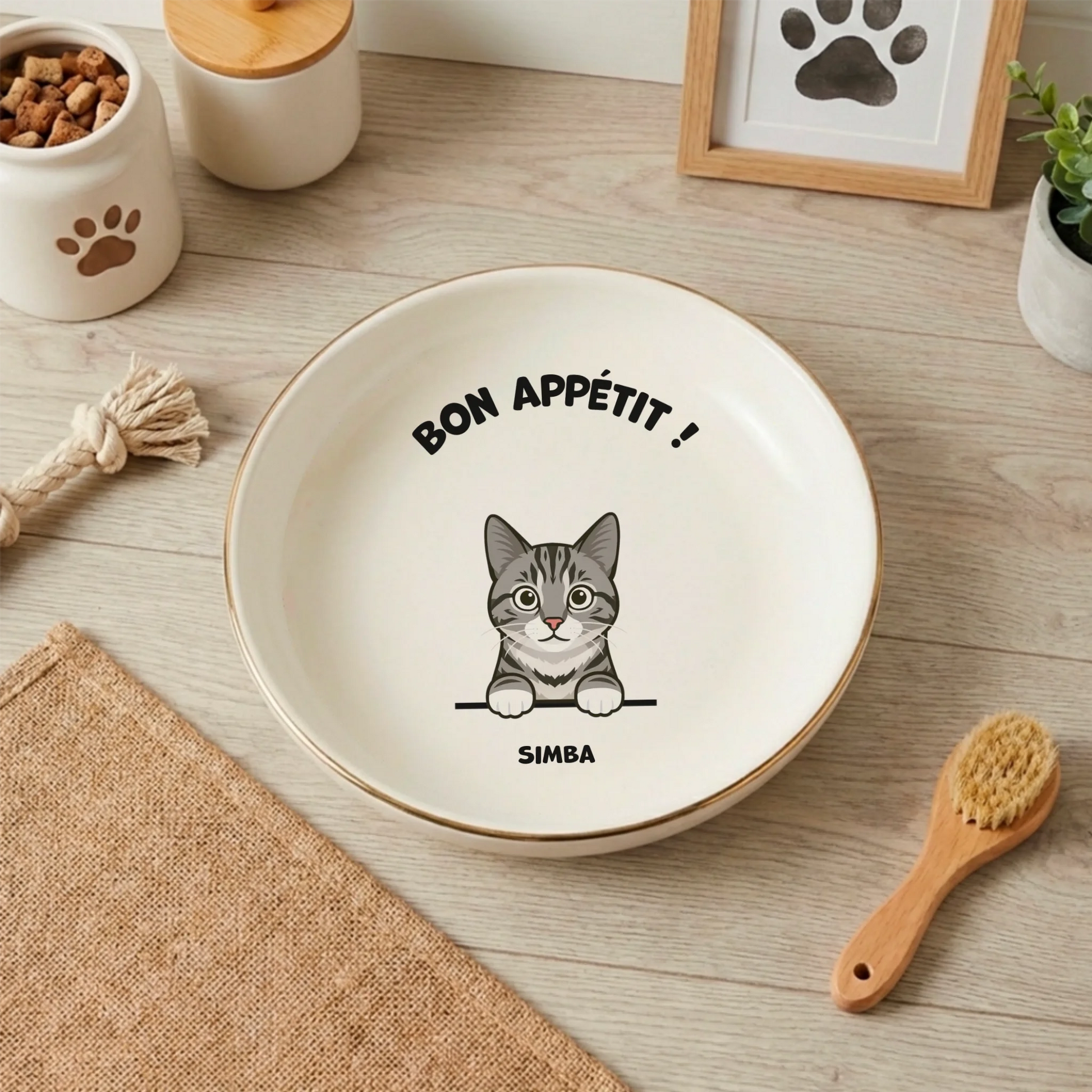 Gamelle chat personnalisée blanche "Bon Appétit" avec illustration de chat tigré et prénom Simba, sur sol en bois.