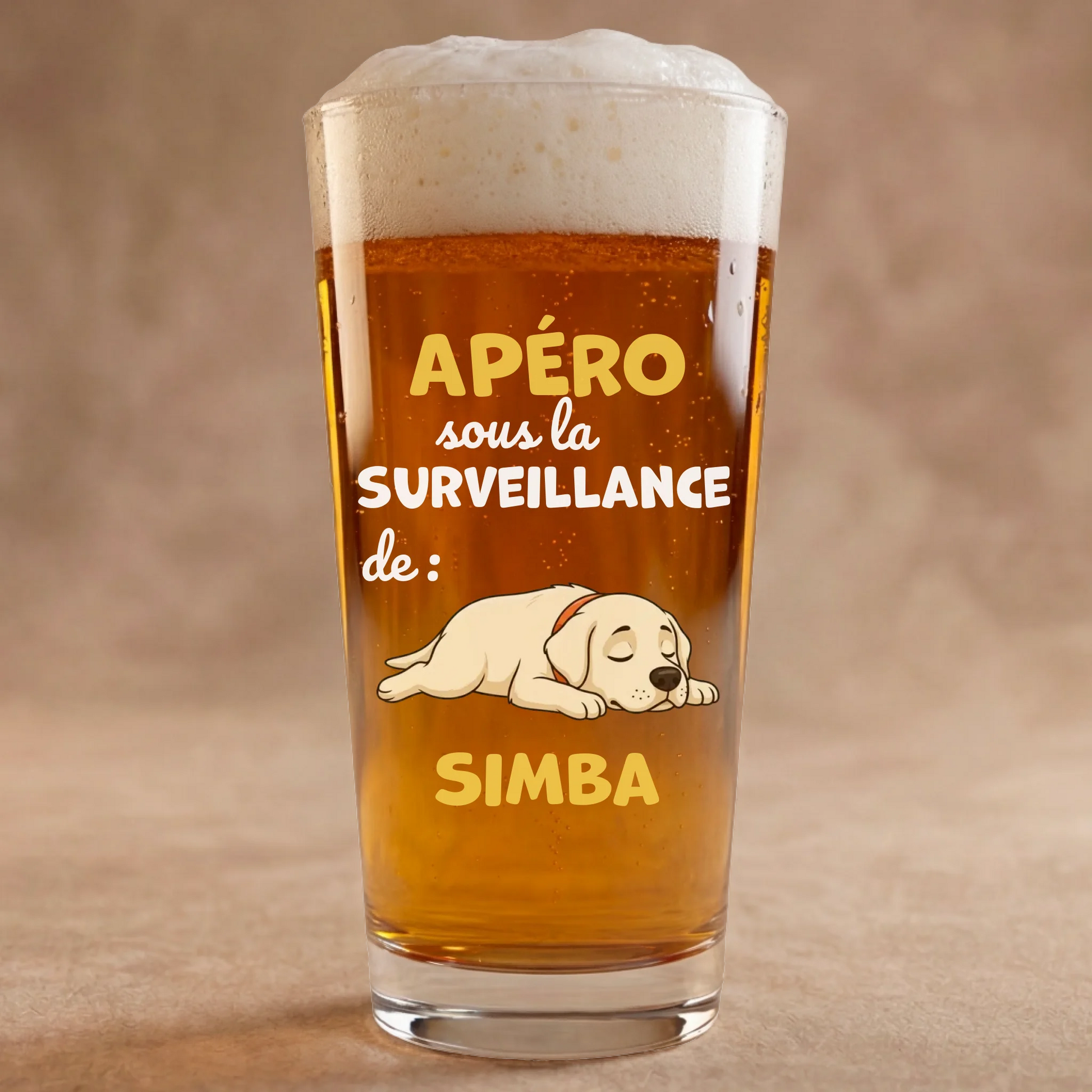 Verre à bière personnalisé avec illustration de chien endormi et texte 'Apéro sous la surveillance de Simba', mousse de bière dorée.