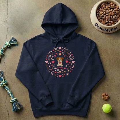 Sudadera con capucha gris en el suelo junto a juguetes de mascota y cuenco de comida.