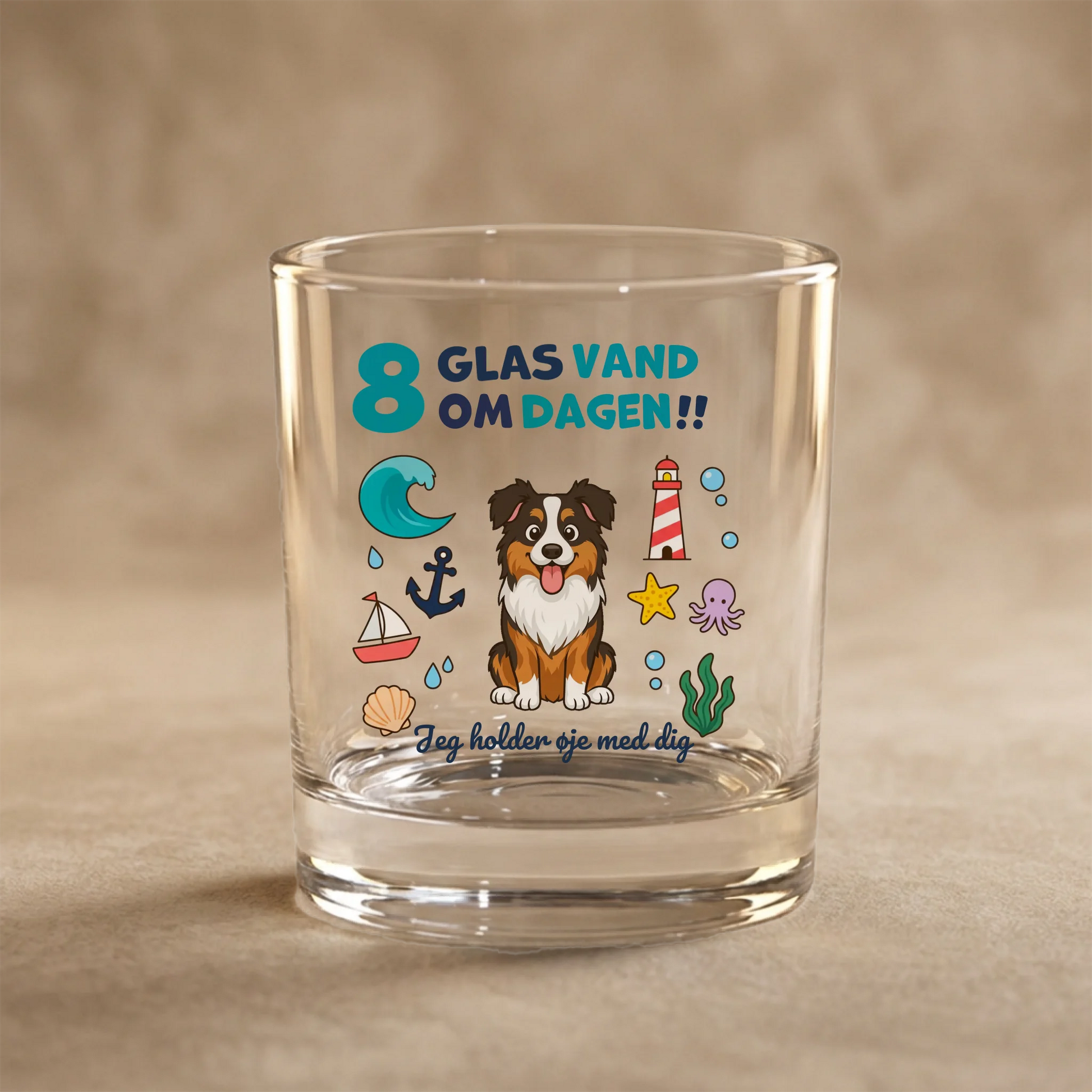 Personligt vandglas med en tegning af en australsk hyrdehund og teksten '8 glas vand om dagen!' omgivet af havtemaer.