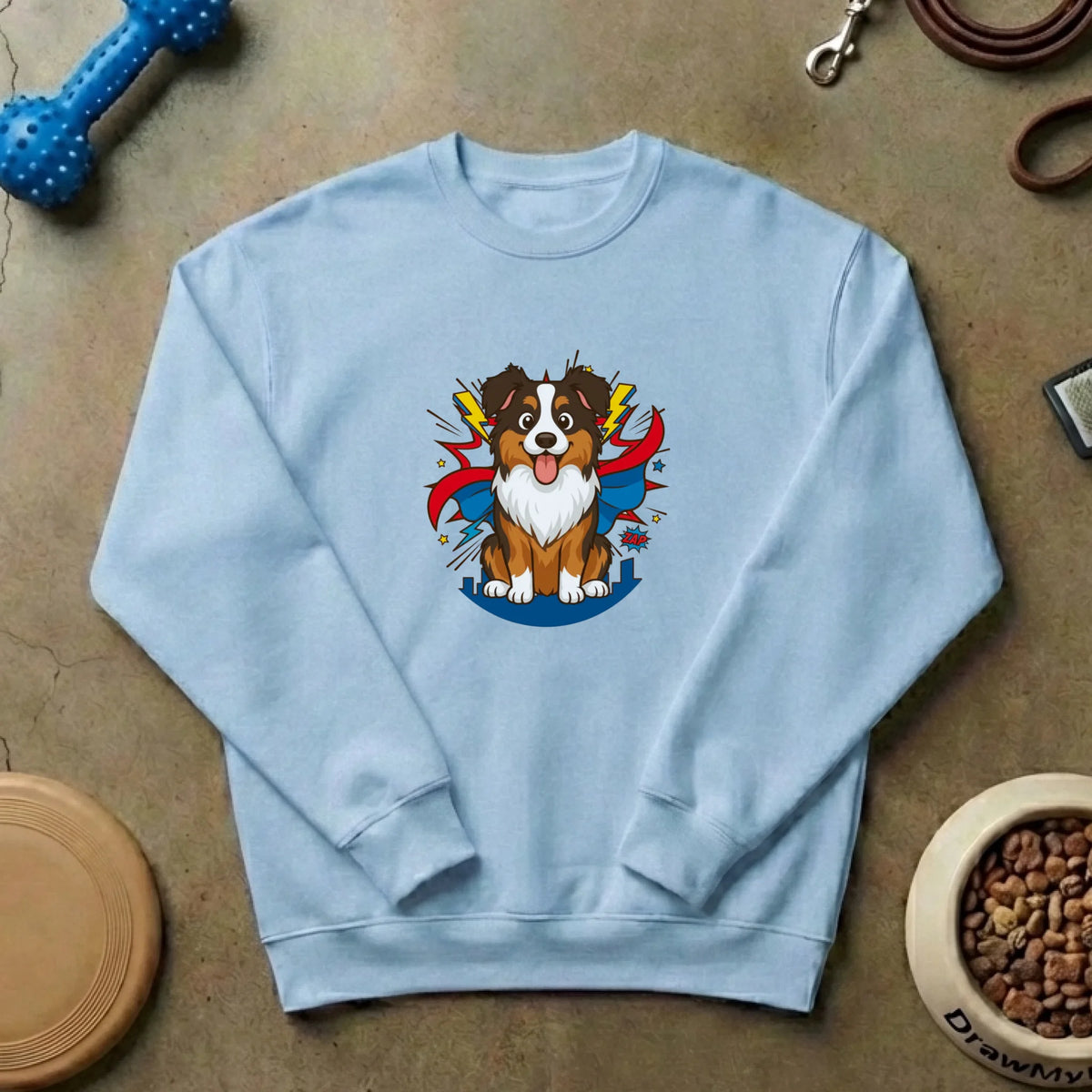 Suéter 'Mi superhéroe' sobre fondo de hormigón con accesorios de perro como hueso y correa