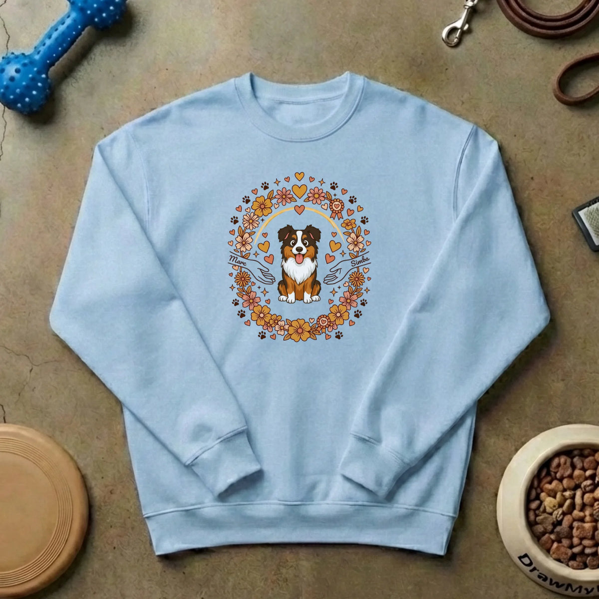 Suéter personalizado de cuello redondo sobre fondo concreto con juguetes y accesorios para mascotas.