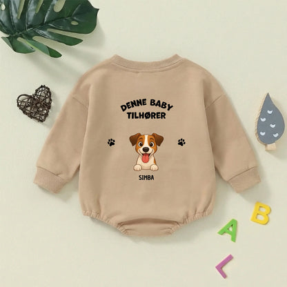 Nærkig af den personlige babybody med tegning af hundehoved og potespor.