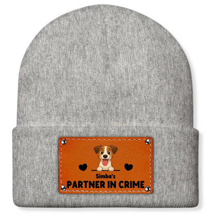 Detail van bruine leren patch met vrolijke cartoonhond en zwarte harten op de muts.