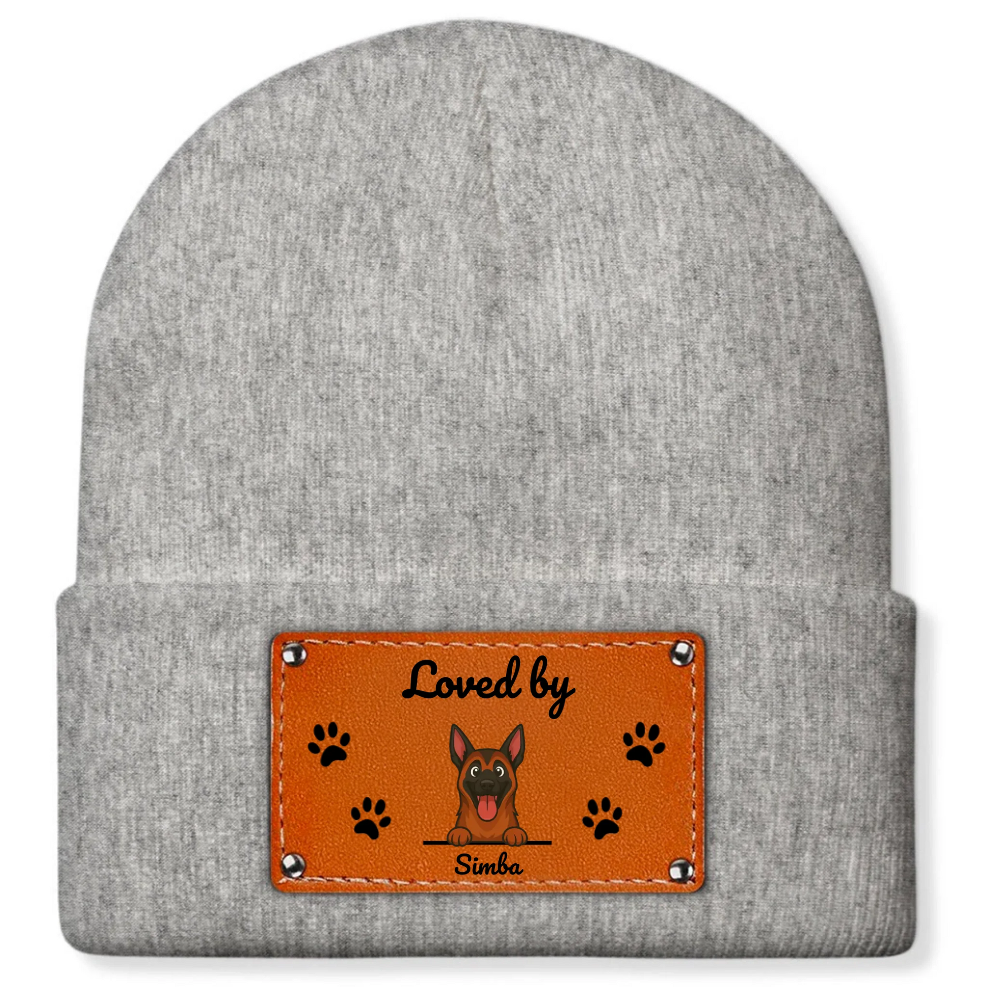 Close-up van de oranje imitatieleer patch met 'Loved by', blije hond en pootafdrukken op de muts.