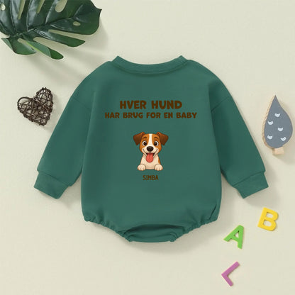 Grøn babybody med teksten 'Hver hund har brug for en baby' og et personligt hundemotiv.