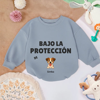 Sudadera de bebé suave en color caramelo junto a juguetes infantiles y manta