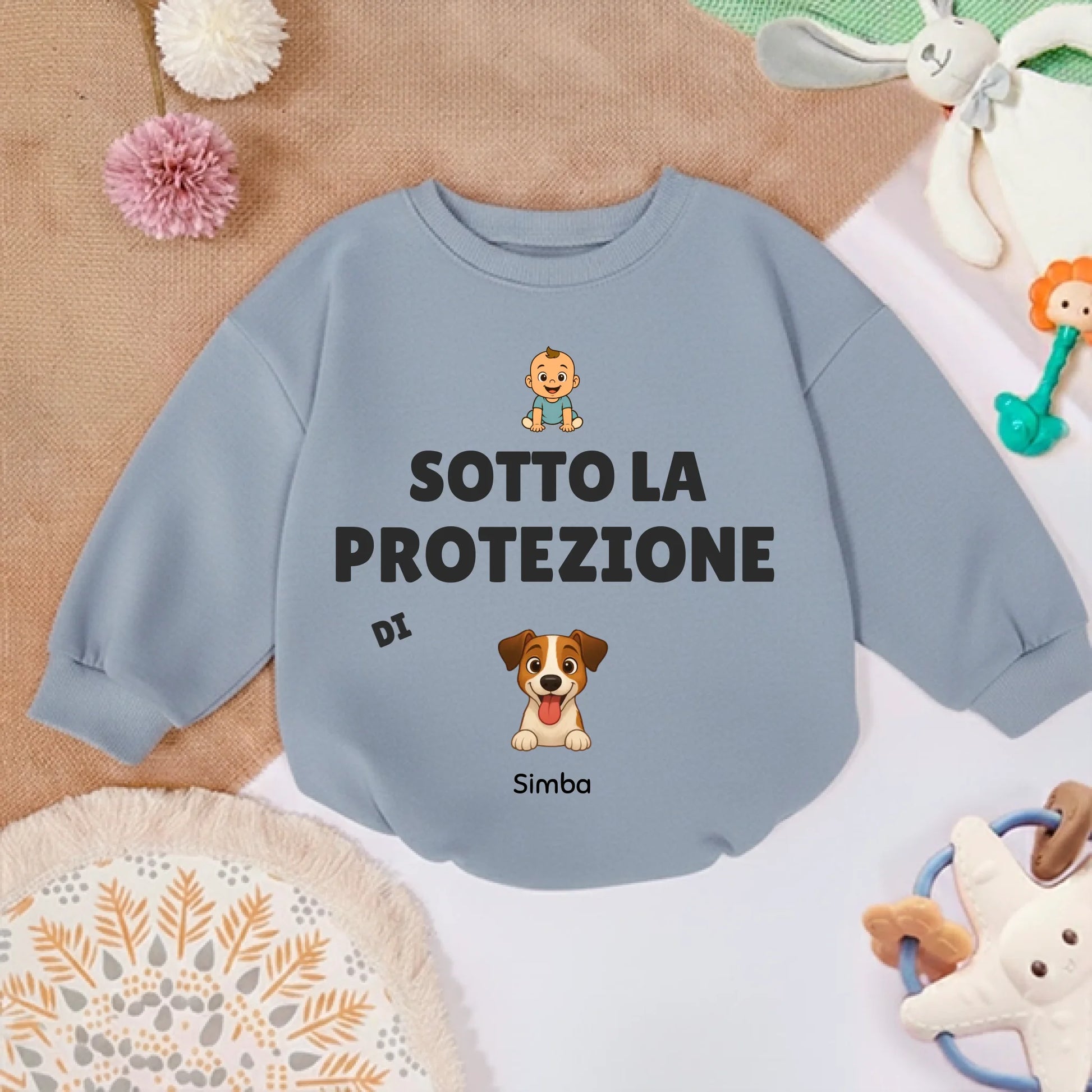 Maglioncino personalizzato per neonato in un contesto di gioco, circondato da giocattoli per bambini.