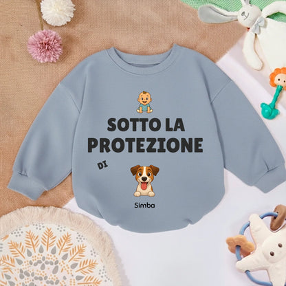 Maglioncino personalizzato per neonato in un contesto di gioco, circondato da giocattoli per bambini.