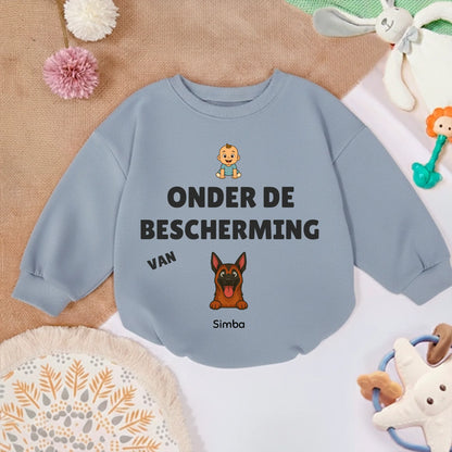 Babytrui met een liefdevolle gepersonaliseerde hondenillustratie, omringd door babyspeelgoed.