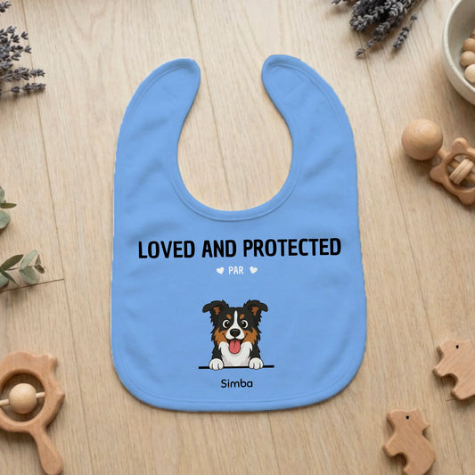 Personalized light blue baby bib with 'Loved and Protected By' slogan and custom dog portrait