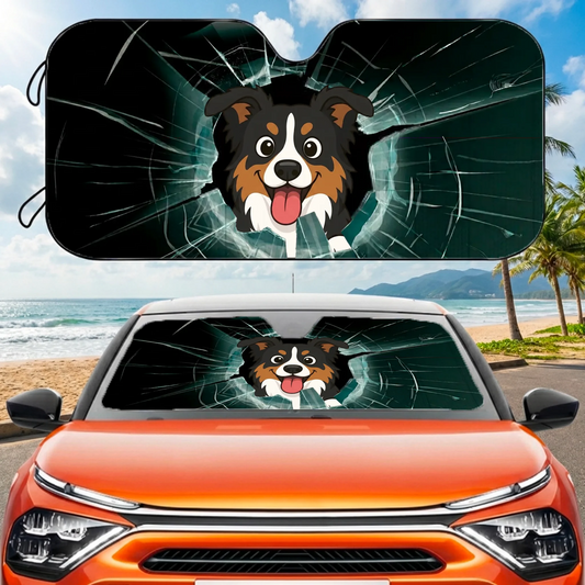 Personalized car sunshade with a cartoon Australian Shepherd dog peeking through a 'broken' windshield effect on an orange car at the beach.