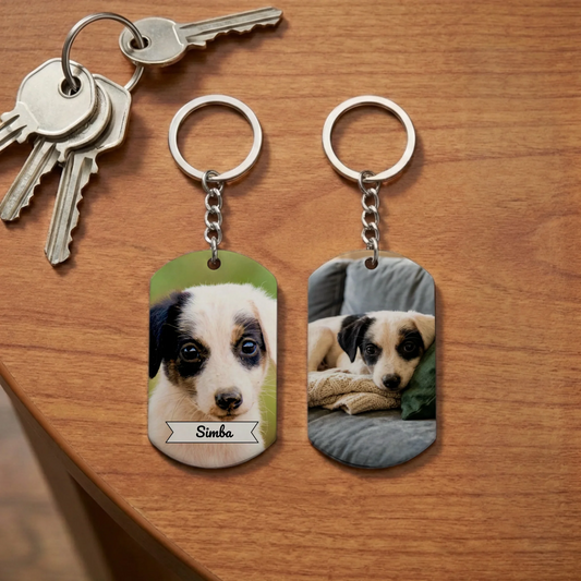 Two personalized dog tag keychains with a puppy's full photo and name 'Simba' alongside a set of keys on a wooden table, showcasing pet love.