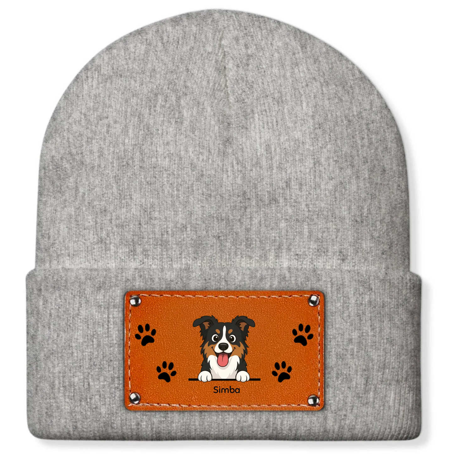 Close-up of the personalized faux-leather patch on a black beanie, showing a cheerful dog portrait, its name, and small paw print details.