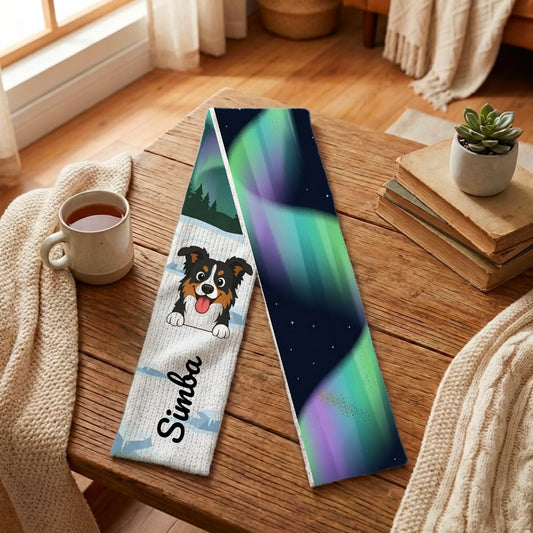 Personalized 'In Santa's Land' scarf with happy dog portrait and name, on a cozy table.