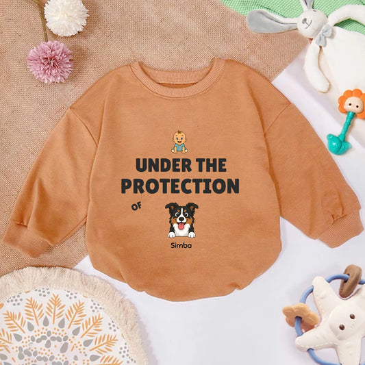 Personalized baby sweatshirt in warm orange featuring a cartoon dog and "Under the Protection of" slogan with pet's name.